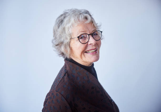 istock Senior woman standing sideways and smiling on a light background 1487773532