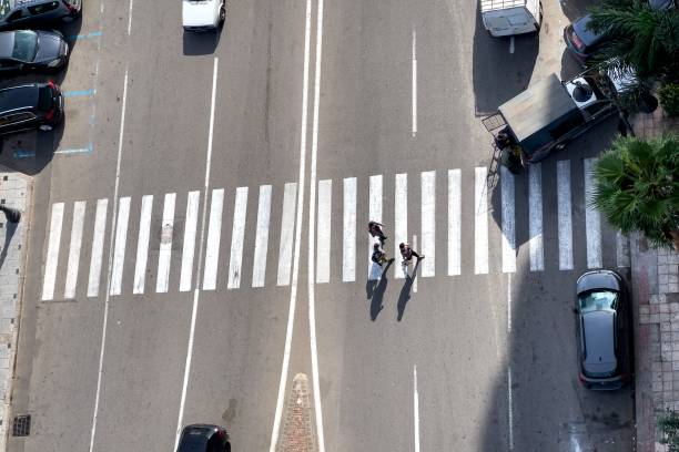 aerial view of pedestrians crossing the zebra lines - zebra walk imagens e fotografias de stock