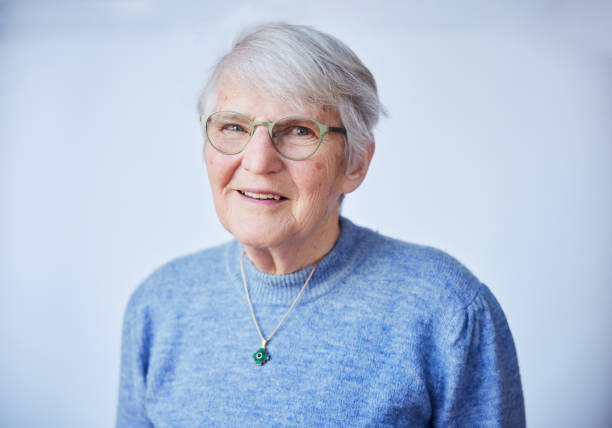 istock Senior woman smiling in front of a light background 1487776416