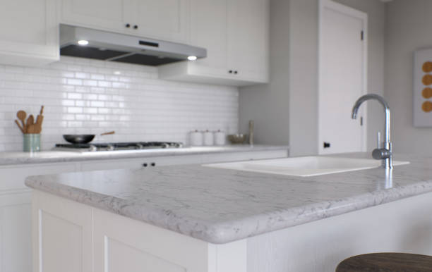 istock Large white kitchen with island and all necessary appliances. 3d rendering. Emphasis on a stone countertop with white marble, in the background a kitchen apron and stove. 1487779074
