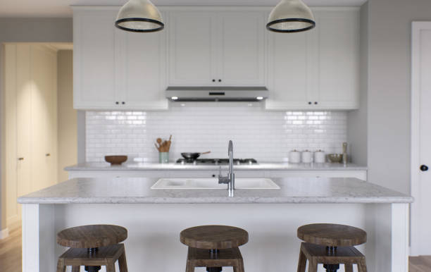 istock Large white kitchen with island and all necessary appliances. 3d rendering. Wooden bar stools, chandelier above the island, large tall cabinets. 1487779107