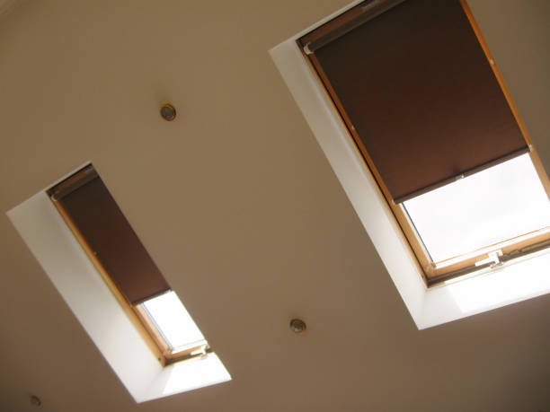Roller blinds on roof windows close up in the interior.