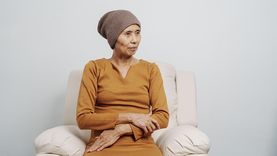 Mature woman suffering from cancer, asian people, 70s years old with headscarf, elderly cancer awareness concept.