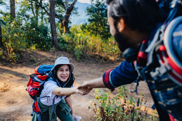 istock Woman hike  being pulled up by helping hand. Hiker friends help each other up a mountain. Man and woman giving a helping hand and active fit lifestyle. Hikers with backpacks helping  friend to climb 1487783954