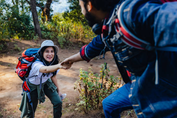 istock Woman hike  being pulled up by helping hand. Hiker friends help each other up a mountain. Man and woman giving a helping hand and active fit lifestyle. Hikers with backpacks helping  friend to climb 1487783955