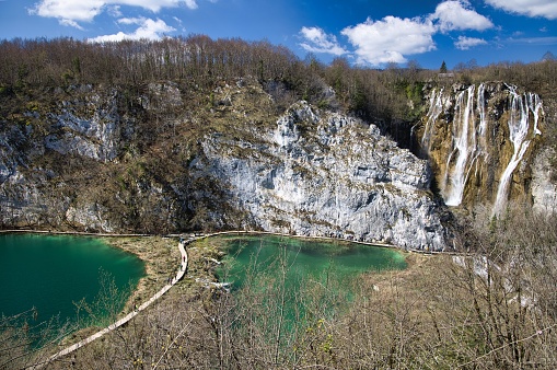 A scenic landscape with a large waterfall surrounded by trees and foliage, Plitvice National Park,
