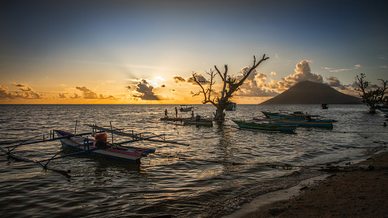 Grand Baie, Mauritius - November 30, 2016: Beach at Grand Baie during Sunset. Clouds create a magical atmosphere in the scenery. People enjoy the evening close to the sea.