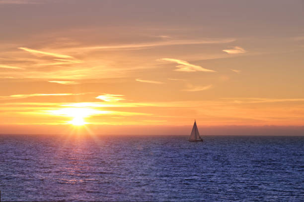istock sunset on the sea with boat on the horizon 1487797836