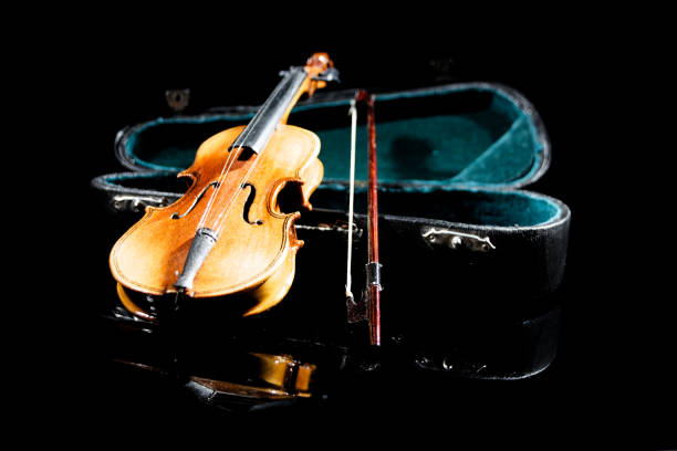 istock small model of an old violin with bag on black surface with black background 1487798807