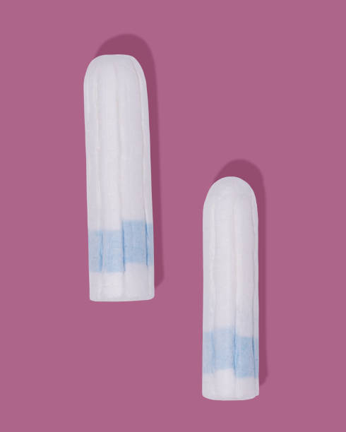 istock Clean cotton tampons with blue string on pink background 1487803786