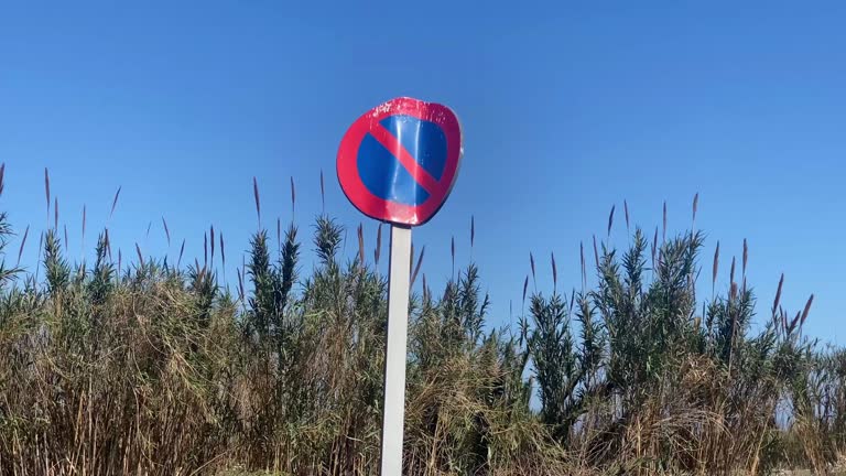 Forbidden sign in front of bushes outdoors