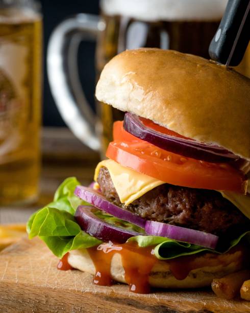 istock Delicious fresh burger with meat and cheese with beer on background 1487805367