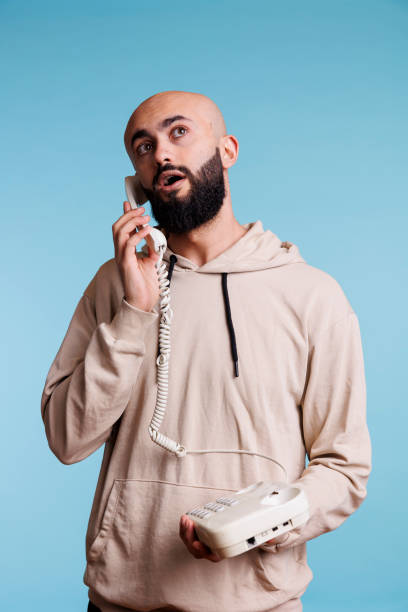 istock Arab man speaking on corded phone 1487807644