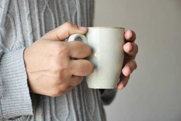istock Close up of women's hand holding coffee mug 1487808054