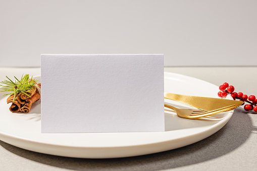 Place card mock-up close-up. Empty card on the plate, winter wedding or Christmas dinner party