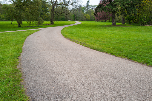 Meandering gravel path seen in the grounds of an English stately home. The grounds extended to thousands of acres.