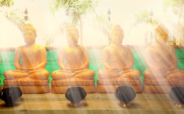 gruppo delle statue del buddha e fascio di luce nel tempio buddista - buddha thailand spirituality wisdom foto e immagini stock