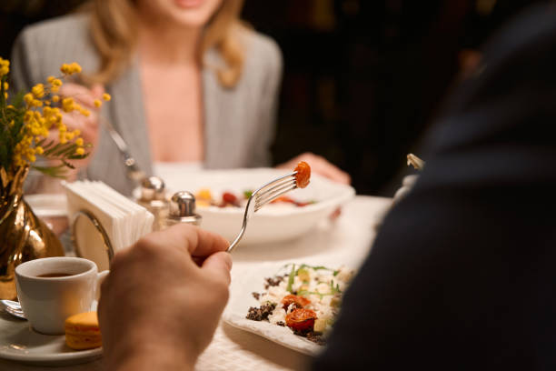 A vibrant cultural celebration features a festive table adorned with an array of traditional dishes, including meats, salads, and beverages enjoyed by guests.