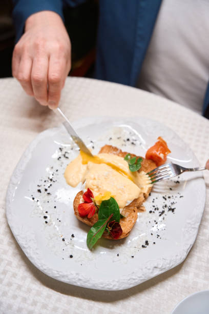 istock Man cutting freshly cooked poached egg with knife 1487815660