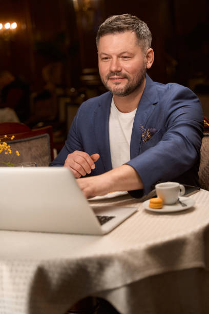 istock Man keeping video call during coffee break at lobby bar 1487815674