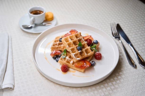 istock Delicious breakfast of coffee and waffles serving on cafe table 1487816282