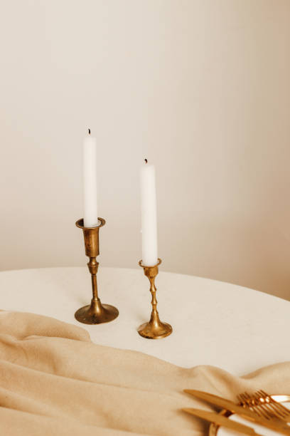 istock Golden candlesticks with white candles in a beige interior 1487816527