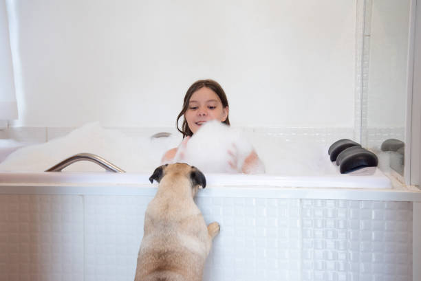 child in bathtub with foam playing with pet outside