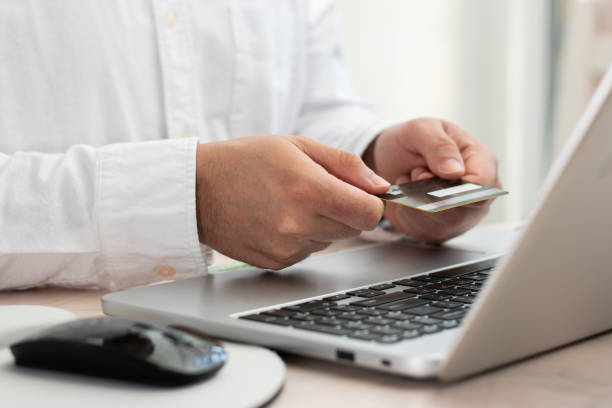 istock Executive holding with two hands a credit card front their laptop for online shopping concept 1487819313