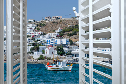 View of fishing boat and Mykonos island from the window.