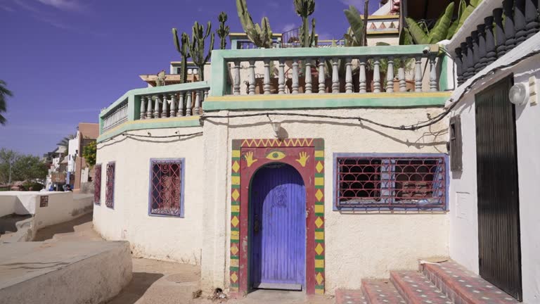 Traveling on a colorful painted door of a traditional old house with Fairy Castle Cactus above on the balcony in Taghazout