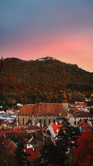 A stunningly beautiful sunset in Brasov, Romania, with a breathtaking view of the old 1689 church in the foreground
