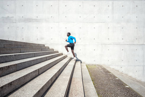 young black sportsman running up steps outdoors - determination running staircase jogging imagens e fotografias de stock