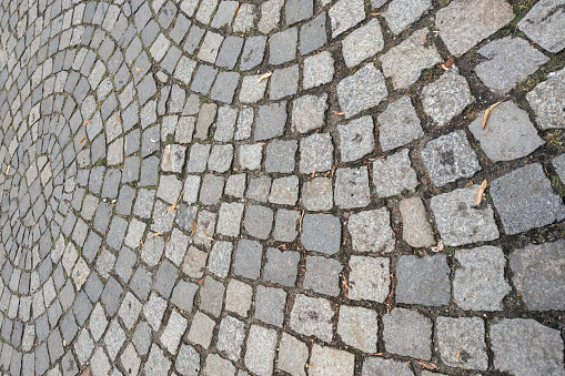 The background is made of paving slabs in the old part of the city. The texture of the stone