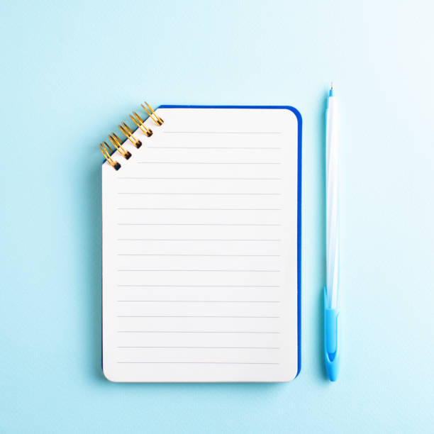 istock Open notebook with blank page and blue pen on blue background. 1487829890