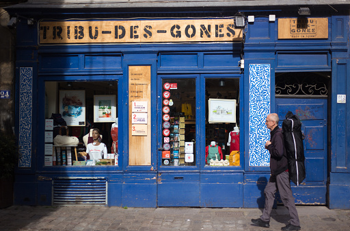 Lyon France: A senior man carries a backpack with an instrument in Vieux Lyon early in the morning.