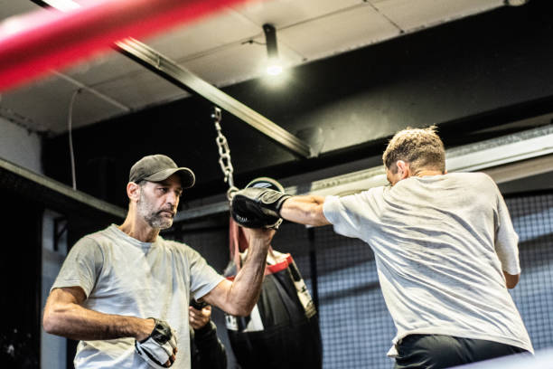 istock Mature trainer training boxing with his student in the ring 1487831752