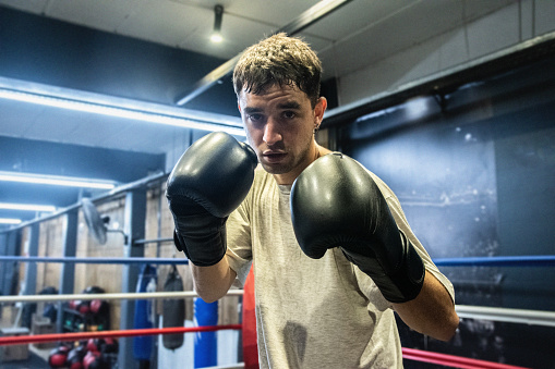 Portrait of a young boxer in fighting pose in the ring
