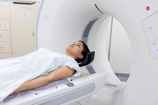 Female patient lying down ready for a CAT scan at the hospital - Healthcare and medicine concepts