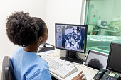 Black female radiologist looking at a patientâs CAT scan to write the report at the clinic