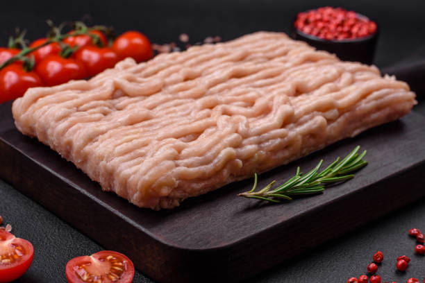 istock Fresh minced chicken with salt, spices and herbs on a wooden cutting board 1487838113