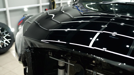 Vehicle detailing. Protective film for car body. Overlaying a vinyl film on the surface of body parts.