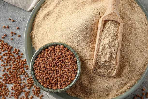 istock Flat lay composition with bowl of buckwheat flour and grains on grey table 1487849046