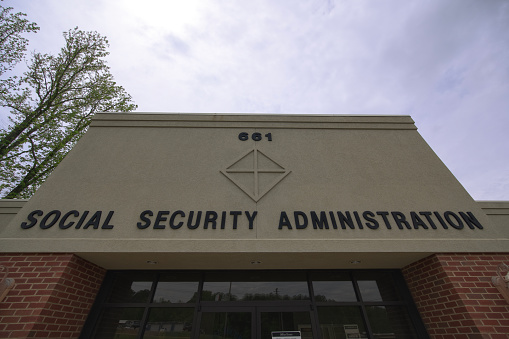 Close up of social security administration sign with copy space above in moody sky