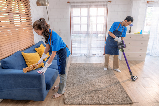 Male and female staff cleaning customers' homes.