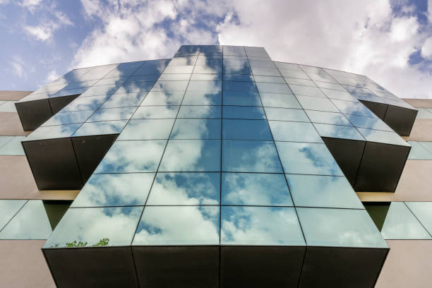 istock Office building facade with lots of mirrors reflecting the sky and clouds 1487852771