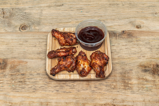 Portion of fried chicken wings with barbecue sauce