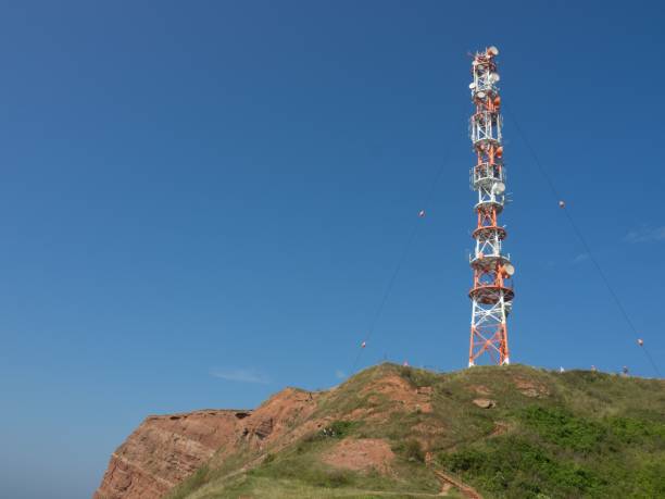 istock Cellular tower standing atop a hill surrounded by a blue sky 1487854617