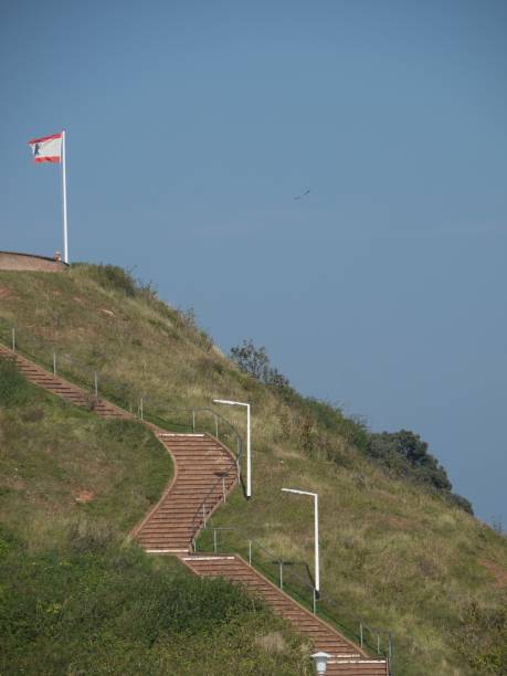 istock Staircase with a flag on top of a grassy hillside 1487854618