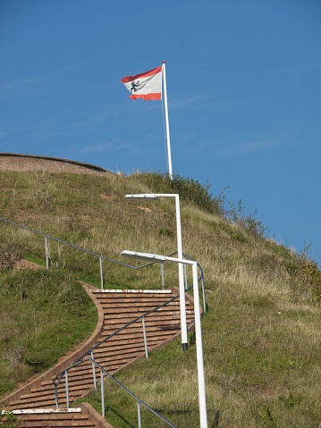 A staircase with a flag on top of a grassy hillside