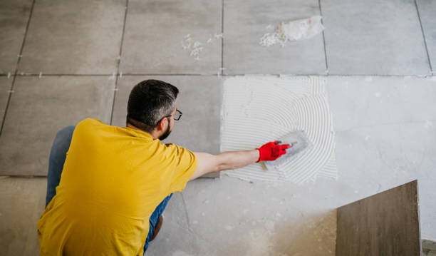 istock Worker places new tile on a floor 1487857452